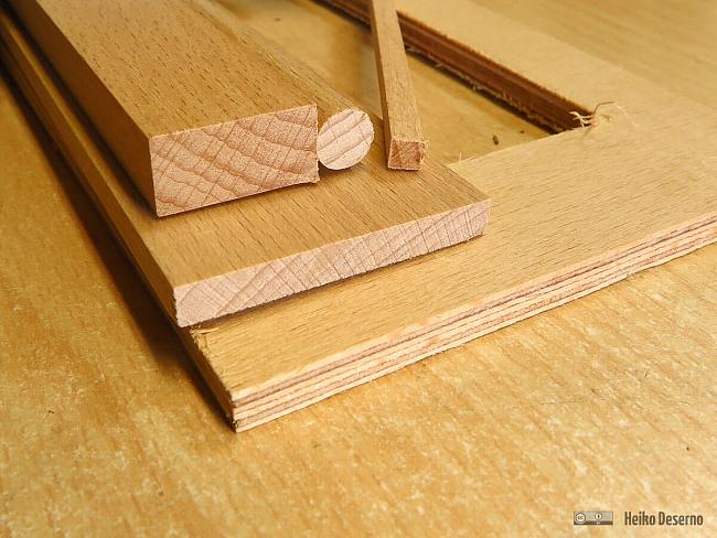 Unten eine Stück Buchensperrholz von Graupner. Darüber Massivholzleisten aus dem Baumarkt und ein Rundholz. Im sichtbaren Bereich stören die Schichten des Sperrholzes.